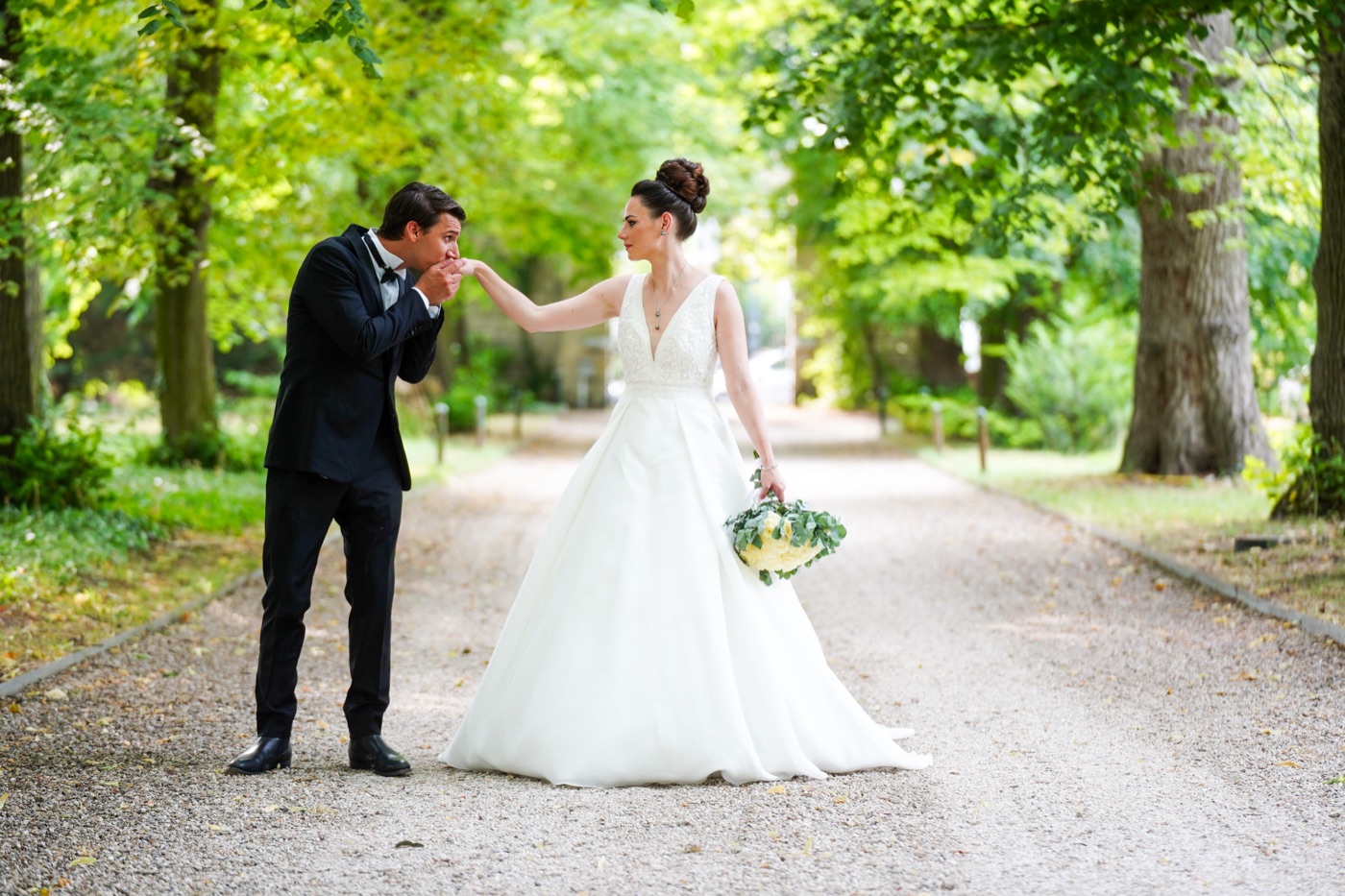Mariés dans une allée bordée d'arbres