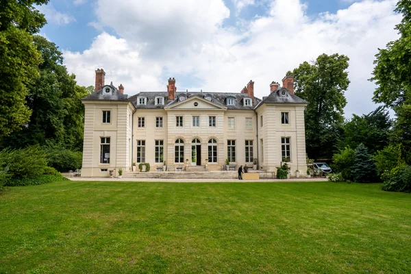 Façade du Château de la Chesnaie à Eaubonne, entourée d’arbres et donnant sur une grande pelouse